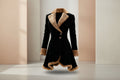 Black women's winter coat with tan shearling trim, structured design, and button closure, ideal for cold weather fashion